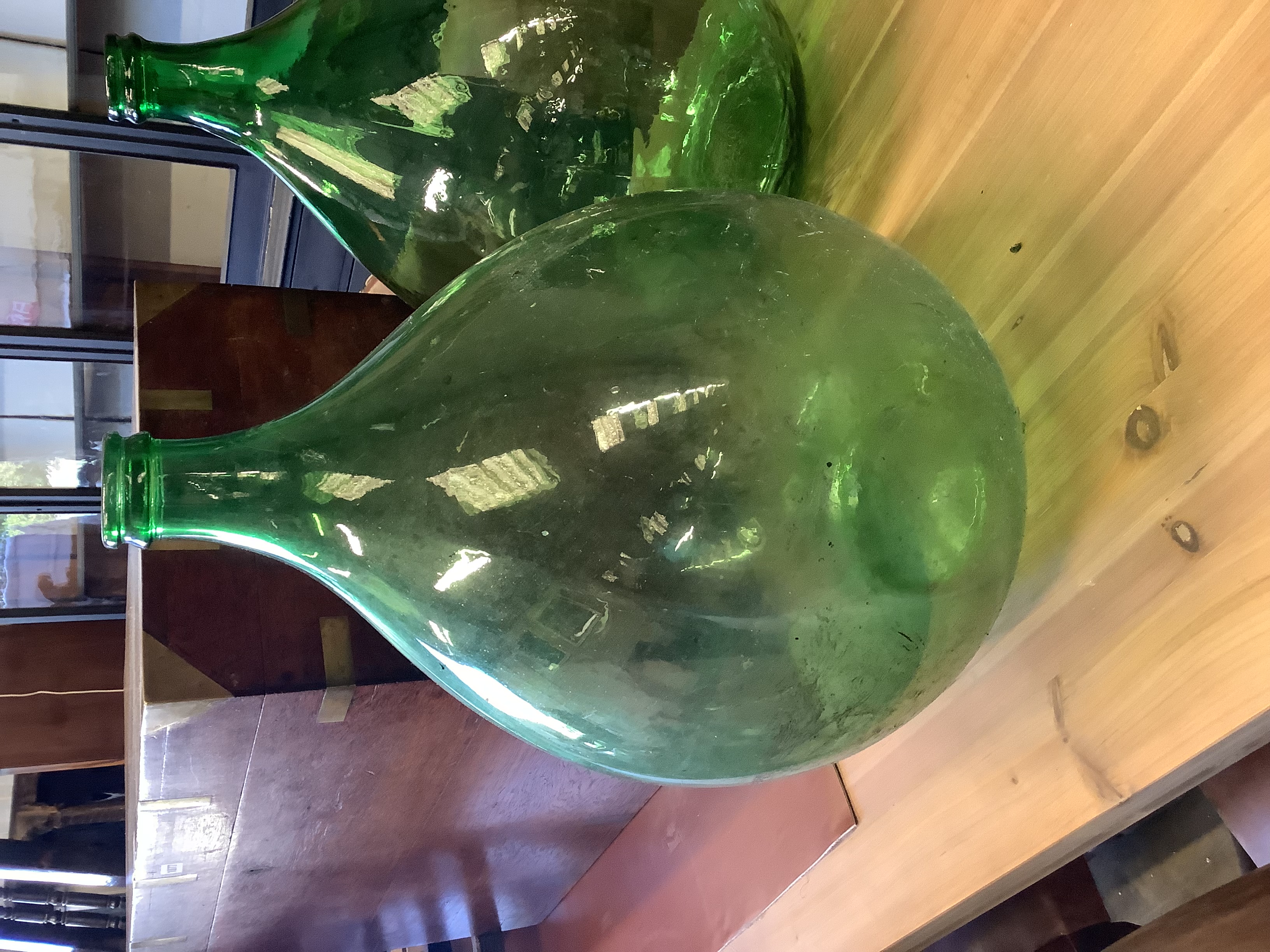 A pair of green glass carboys, height 64cm